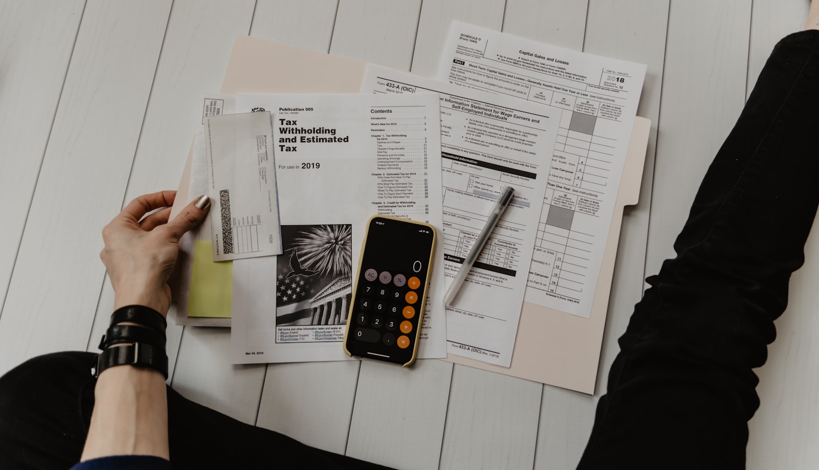 Consultant freelance calculant son tarif journalier moyen sur un ordinateur portable avec calculatrice et notes